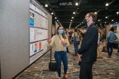 Picture of Natalie describing her poster to a conference participant