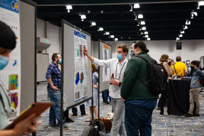 Russell Miller explains his poster to a conference participant